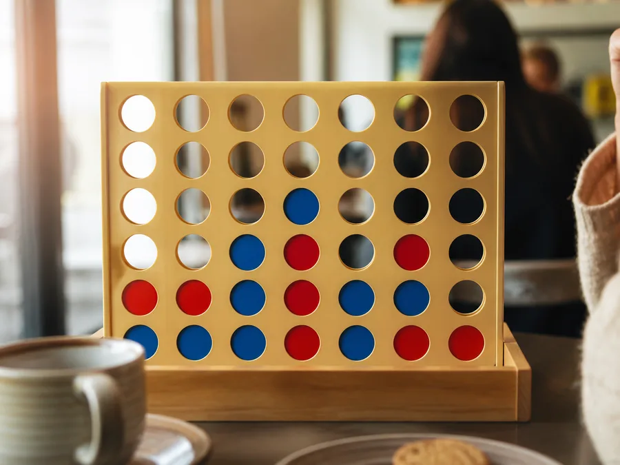 A 7×6 Four in a Row opening with red and blue discs stacking from the bottom